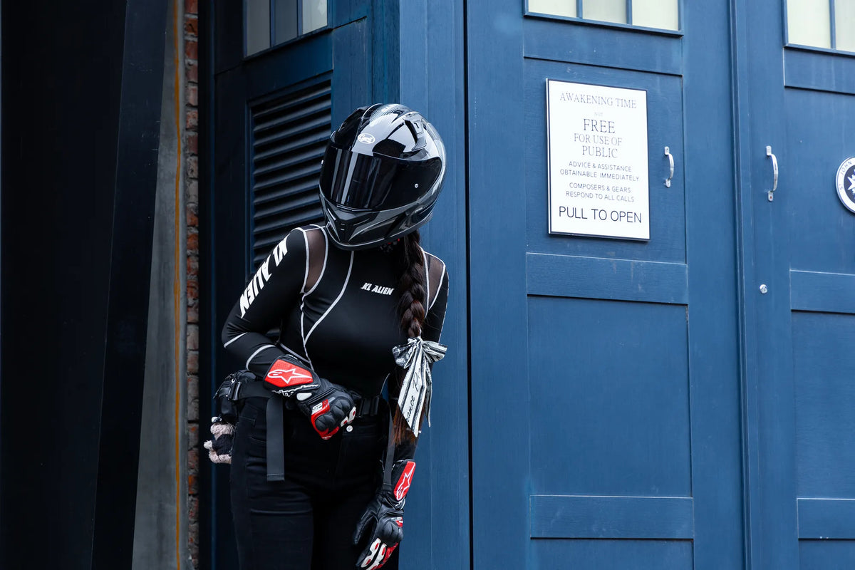 Rider in a full-face helmet standing in a blue doorway