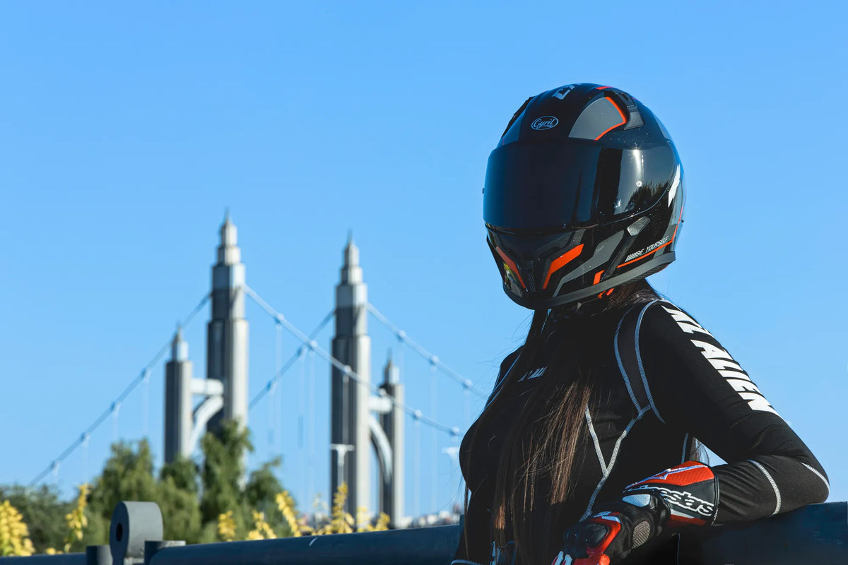 Rider in a dark full-face helmet looking toward a city skyline