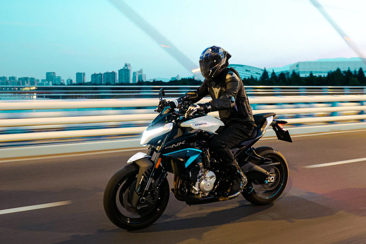 Rider in a full-face helmet riding a naked bike on a waterfront road