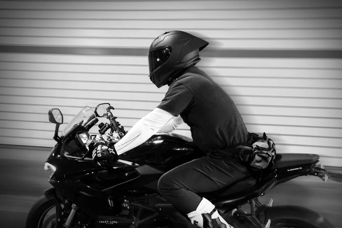 Rider in a black full-face helmet on a sport bike, black and white photo