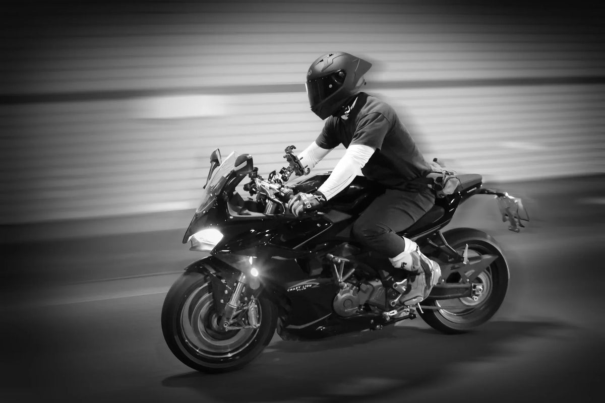 Rider in a full-face helmet on a sport bike, black and white photo