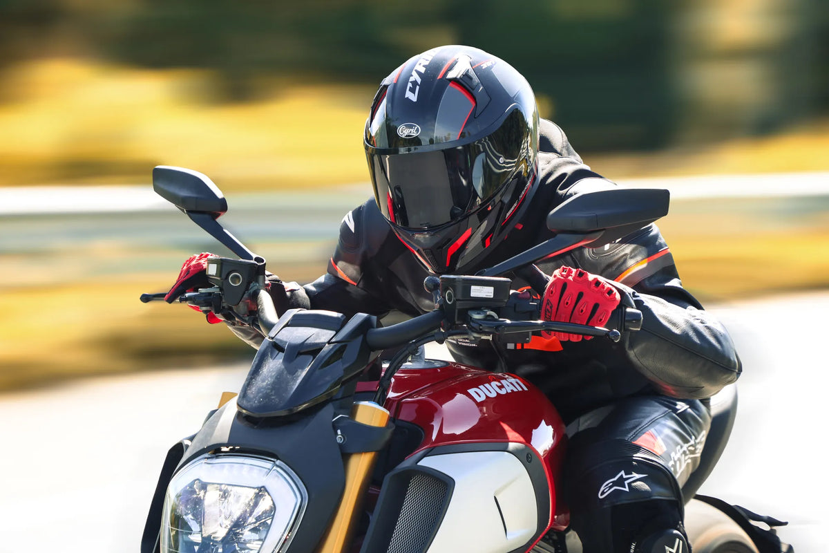 Rider in a black and red full-face helmet on a red naked bike