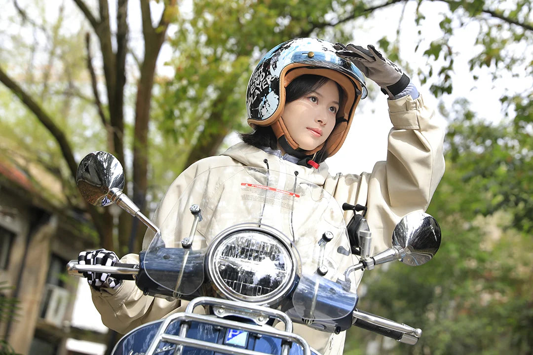 Rider adjusting an open-face helmet while sitting on a scooter